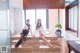 A couple of women sitting on top of a marble counter.