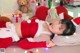 A woman in a santa outfit laying on the floor.