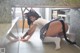 A woman in a white shirt and black cat ears is posing on the floor.