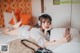 A woman laying on a bed with headphones and a cell phone.