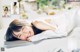 A woman laying on a bed smiling at the camera.