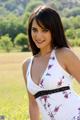 A woman in a white dress posing in a field.